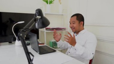 Ofiste dizüstü bilgisayar kullanan Asyalı genç işadamının portresi..