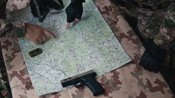 司令官はテーブルで戦略を立て 地図上で行動を計画する 軍事チームワーク 戦術的な議論 調整が日中に展開される — ストック動画