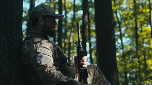 Zmęczony Żołnierz Lesie Zakładający Czapkę Siedzący Cieniu Drzewa Słoneczny Dzień — Wideo stockowe