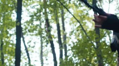 Bir orman ortamında, tetikte bir asker, AK-47 ile silahlanmış, dikkatli bir şekilde doğada geziniyor..