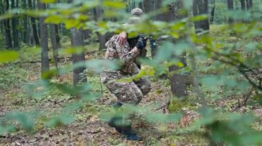 Ormanın ortasında, bir asker yaralı bir meslektaşına yardım ediyor, savaşta takım çalışması sergiliyor.. 