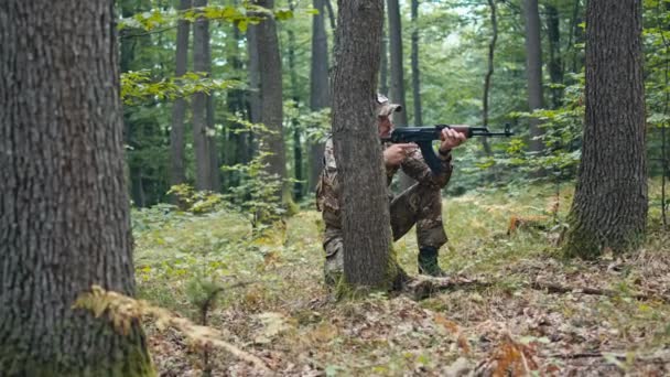 携带Ak 47冲锋枪的士兵在森林中保护小组 在推进的过程中利用树木作为掩护 — 图库视频影像