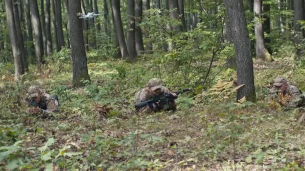 Tři Vojáci Ozbrojení Puškami Plazí Lesem Zatímco Nad Nimi Létá — Stock video