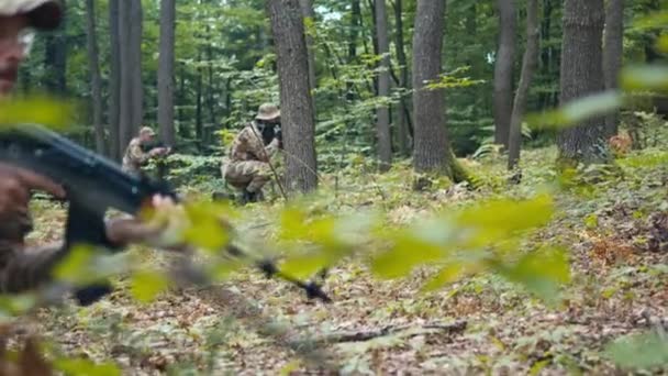 一队军人蹲伏在森林里 小心翼翼地向前走 — 图库视频影像