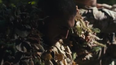 İki asker güneşli bir günde ormanda savaşmak için üniformalarını hazırlıyorlar..