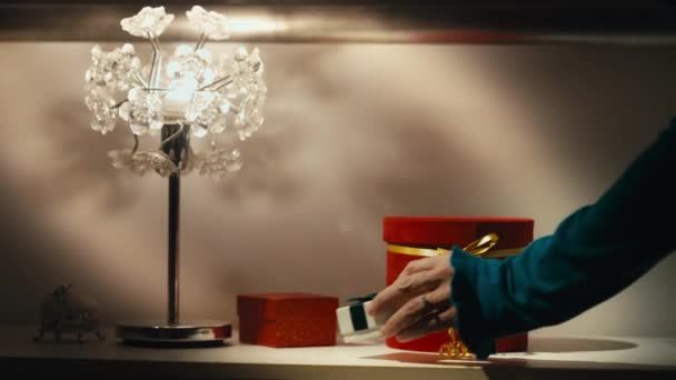 雌性的手巧妙地在桌上布置了一个白色礼品盒 上面有一个蓝绿色的蝴蝶结 周围都是其他礼物 完美的假日准备 节庆活动和特别活动 — 图库视频影像