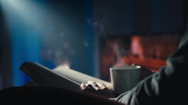Людина Насолоджується Затишним Вечором Чашкою Чаю Книгою Біля Каміна Тепла — стокове відео