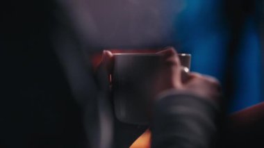 Bir kadın şöminenin yanında sıcak bir akşam geçirmekten zevk alır. Sıcak atmosfer ve huzur ortamı rahatlama ve yansıma için mükemmel bir an yaratır..