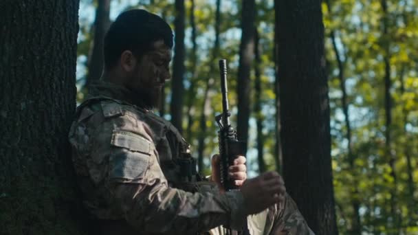 一个疲惫的士兵在森林里检查他的杂志 却发现他的弹药不多了 — 图库视频影像