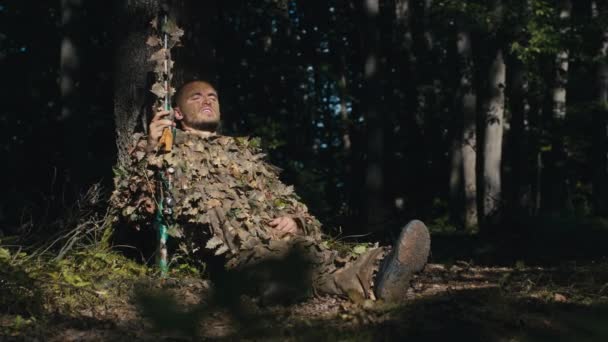一个身穿迷彩服 手拿着狙击步枪 精疲力竭的疲惫士兵站了起来 他走进森林的黑暗中 — 图库视频影像