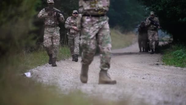 指揮官の指示の下で汚れた道を慎重に歩いている軍隊の部隊 — ストック動画