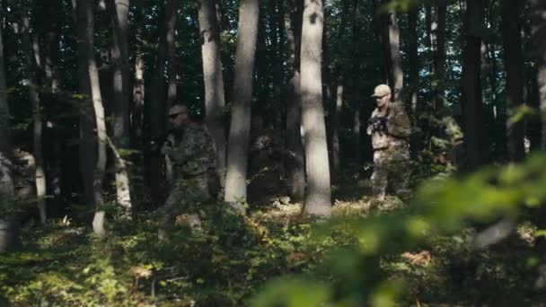 Oddział Wojskowy Biegnie Między Drzewami Podczas Gdy Dron Lata Nimi — Wideo stockowe