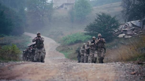 Escuadrón Militar Corriendo Cuesta Arriba Camino Tierra Rastros Casas Arruinadas — Vídeo de stock