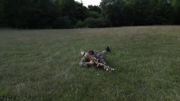 Plan Orbite Sniper Allongé Sur Herbe Tirant Travers Une Lunette — Video