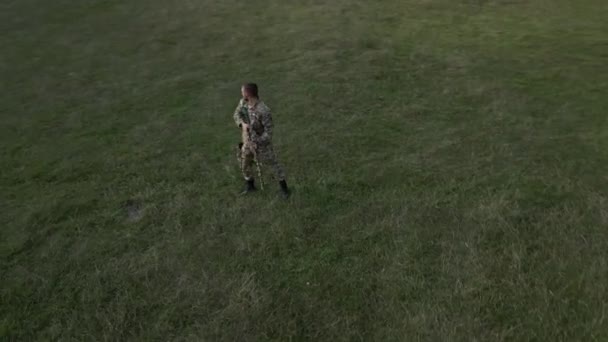 Орбитальный Снимок Снайпера Оглядывающегося Вокруг Затем Лежащего Траве Целящегося Через — стоковое видео