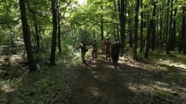 Drone, yaprak döken bir ormanda koşan yedi askerlik bir grubu takip ediyor. Tüfeklerle donanmış ekip, askeri taktikler sergiliyor, profesyonel ve ihtiyatlı bir şekilde açık hava eğitimi sergiliyor.. 