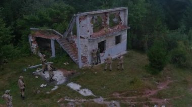 Drone, harabe bir evde düşman askerlerini kuşatıp esir alan taktik eğitimdeki bir ordu mangasını yakalıyor. Silahlı profesyonel askeri grup, dışarıda stratejik bir savaş başlattı..