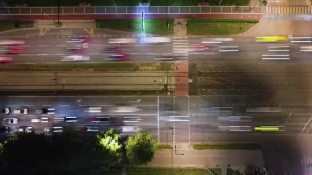从上到下的时间捕捉到了夜晚繁忙的城市交叉口的喧嚣 车辆穿过繁华的街道 留下迷人的小径 城市生活的动态 — 图库视频影像