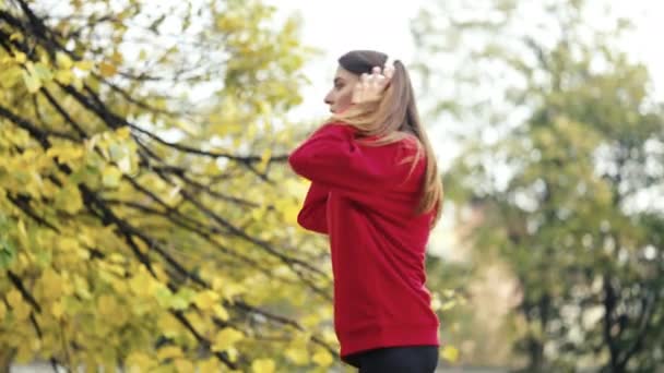 アクティブな若い女性は屋外に伸びるためにジョギングを一時停止し スマートフォンをチェックし ジョギングを続けます 秋の健康的なルーチン中にフィットネス 自然を取り入れる — ストック動画