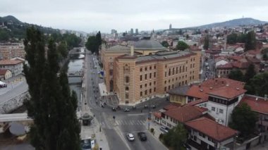 Saraybosna Belediye Binası 'nın önünden geçen motorcuların Hava Çekimini Uzaklaştır. Dinamik hareketi yakalıyor ve grup şehir sokaklarında dolaşıyor..