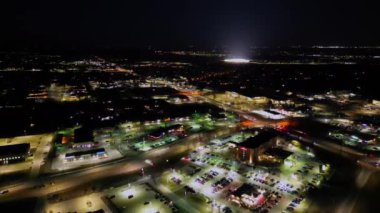 Batı Des Moines, Iowa 'nın hava indirme manzarası. Şehir manzarası aydınlanmış sokaklar ve şehir merkeziyle canlanıyor. Aydınlatılmış bir stadyum uzaktan görülebilir..
