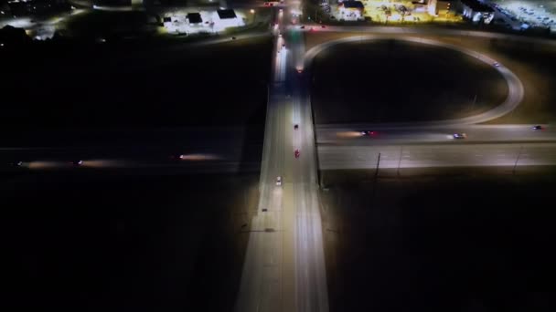 アリアルジブショットは 夜にデモインで賑やかなハイウェイ交差点をキャプチャします 都市の交通は橋の下と上をシームレスに流れ 交通とライトの鮮やかな光景を作り出します — ストック動画