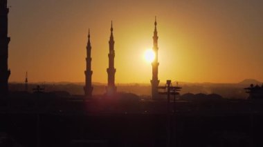 Sabah güneşi Medine 'de Kahinler Camii' ni altın bir saatte yıkarken. Bu video ikonik İslami mimarinin ruhsal özünü yakalar, minareler ve huzurlu bir şehir manzarası içerir..