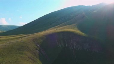 Balkanlardaki dağların zirvesinden yükselen güneşin parlaklığının havadan görünüşü. Manzarası, parlak güneş ışığı ve muhteşem Dinarik Alpleri üzerindeki panoramik manzaralar..