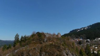 Balkanlar 'daki bir ortaçağ kalesinin kalıntılarının havadan görünüşü. İnsansız hava aracı, Bosna 'nın kış mevsiminde tarihi yansıtan bir haçla antik taş yapıyı yakalıyor..