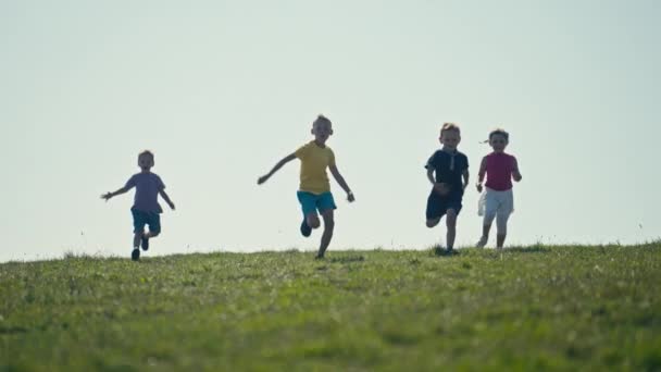 Four Children Run Sunny Meadow Camera Embodying Excitement Freedom Active — Stok video