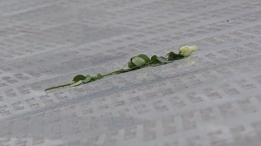 Beyaz gül, Srebrenica Anıt Merkezi 'ndeki taştan bir anıta kazınmış. Kurbanları anmak, onurlandırmak ve Srebrenica soykırımını anmak kavramı.