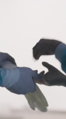 Dikey Ekran: Ameliyattan önce steril eldiven takan tıp uzmanları, temiz ve güvenli bir prosedür sağlıyorlar. Hastane ortamında cerrahi hazırlık, hijyen ve takım çalışması kavramı.