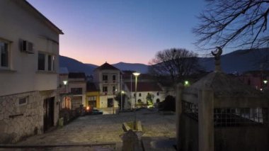 Geleneksel mimari ve aydınlatılmış sokak lambalarıyla alacakaranlıkta tarihi bir şehir olan Mostar 'ın manzarası. Kültürel miras ve İslami hilal sembolü kavramı.