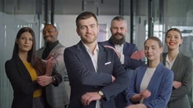 Modern ofis ortamında kendine güvenen resmi giyinmiş profesyonel iş ekibi. Şirket ortamlarında takım çalışması, liderlik ve çeşitlilik kavramı.