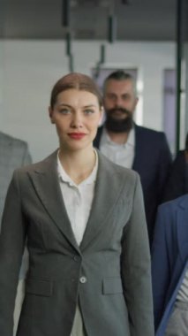 Dikey Ekran: Bir ofis koridorunda birlikte yürüyen, takım çalışması, liderlik ve profesyonellik sergileyen kendine güvenen bir grup profesyonel. Kurumsal başarı ve çeşitlilik kavramı.