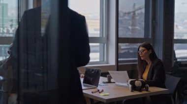 Modern bir ofiste çeşitli takım üyeleriyle yapılan iş toplantısı. Belgeler üzerinde işbirliği yapmak, gülmek ve tartışmalara girmek. Profesyonel işbirliği kavramı ve pozitif işyeri kültürü.