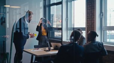 Modern bir ofiste beyin fırtınası yapan iş adamları ile ilgili. İş yerinde takım çalışması, yenilik ve teknoloji güdümlü işbirliği kavramı.