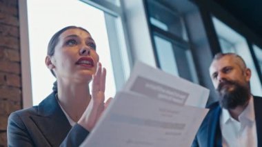Modern bir ofiste resmi bir toplantıda belgelerini sunan profesyonel bir iş kadını. Takım çalışması, kurumsal iletişim ve profesyonel işbirliği kavramı