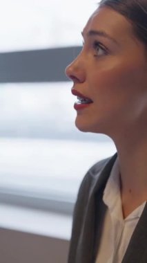 Dikey Ekran: Profesyonel bir toplantıda kendinden emin genç iş kadını, tutkuyla konuşuyor ve iş arkadaşlarıyla konuşuyor. Liderlik, iletişim ve takım çalışması kavramı.