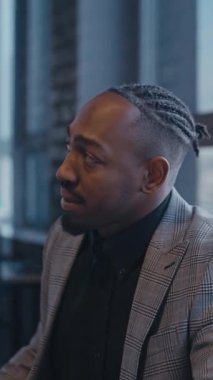 Dikey Ekran: Afro-Amerikan profesyonel bir iş toplantısı sırasında dikkatle dinliyor, aktif bağlılık ve anlayış gösteriyor. İletişim ve kurumsal işbirliği kavramı.