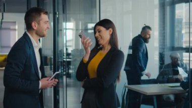 Modern ofis ortamında başarılı bir anı kutlayan iki iş adamı. Şirket ortamında takım çalışması, işbirliği ve başarı kavramı