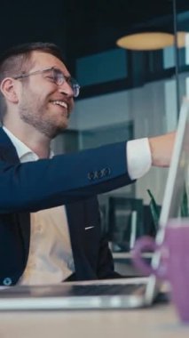 Modern bir ofiste iş toplantısı, takım elbiseli, güler yüzlü ve sohbete dalmış kendinden emin bir adam. Profesyonel işbirliği kavramı, pozitif kurumsal çevre.