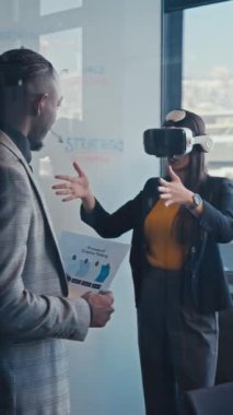Dikey Ekran: Modern bir ofisteki meslektaşlar yaratıcı bir beyin fırtınası sırasında sanal gerçeklik teknolojisiyle etkileşime geçiyorlar. İş ortamında yenilik, takım çalışması ve teknoloji kavramı.