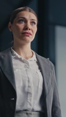 Dikey Ekran: Gri takım elbiseli bir iş kadını ağzındaki bandı çıkarıyor ve derin derin nefes alıyor, profesyonel bir çevrede rahatlama ve güç göstergesi olarak. Özgürlük ve kendini ifade etme kavramı