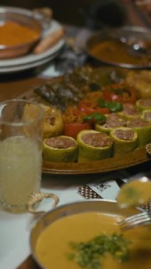 Dikey Ekran: Geleneksel Ortadoğu ve Türk yemekleri ahşap bir tabakta servis edilerek dolma, kabak dolması, domates ve üzüm yapraklarıyla servis ediliyor. Orijinal mutfak, ev yapımı yemekler, iftar..