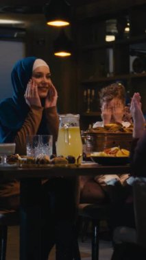 Dikey ekran: Müslüman bir kadın ve çocuğun Ramazan ayında kahvaltı etmeden önce dua edişinin yavaş çekim görüntüleri. İslami maneviyat kavramı, aile bağı, dua, dini bağlılık.