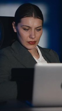 Dikey Ekran: İş kadını gece geç saatlere kadar loş bir ofiste çalışıyor, yorgunluk ve hayal kırıklığını gösteriyor. Esniyor, şakaklarını ovalıyor ve dizüstü bilgisayarına odaklanmaya çalışıyor. İş yorgunluğu