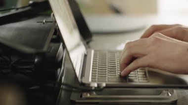 Modern çalışma alanında dizüstü bilgisayarda klavyeyle yazı yazan, kol saati takan ve göreve odaklanmış erkeklerin yakın çekimleri. Uzaktan çalışma kavramı, dijital verimlilik, teknoloji ve ofis rutini.