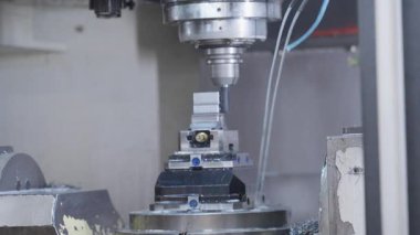 Yüksek hassasiyetli metal imalatı sırasında, soğutma sıvısı püskürtme ve kesme aletleriyle CNC makinesine yakın çekim. Endüstriyel otomasyon, makine ve metal üretimi kavramı.