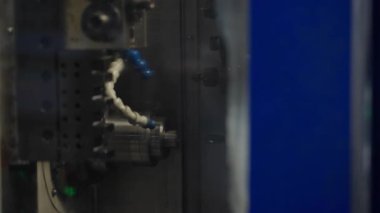 Yüksek hassasiyetli metal işleme sırasında CNC makinesinin içindeki soğutucu spreyler otomatikleştirilmiş imalatın karmaşıklığını vurgular. Endüstriyel makine teknolojisi kavramı.